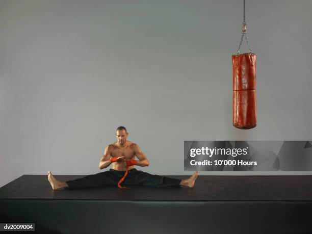 male boxer stretching next to a punch bag - elastic bandage fotografías e imágenes de stock