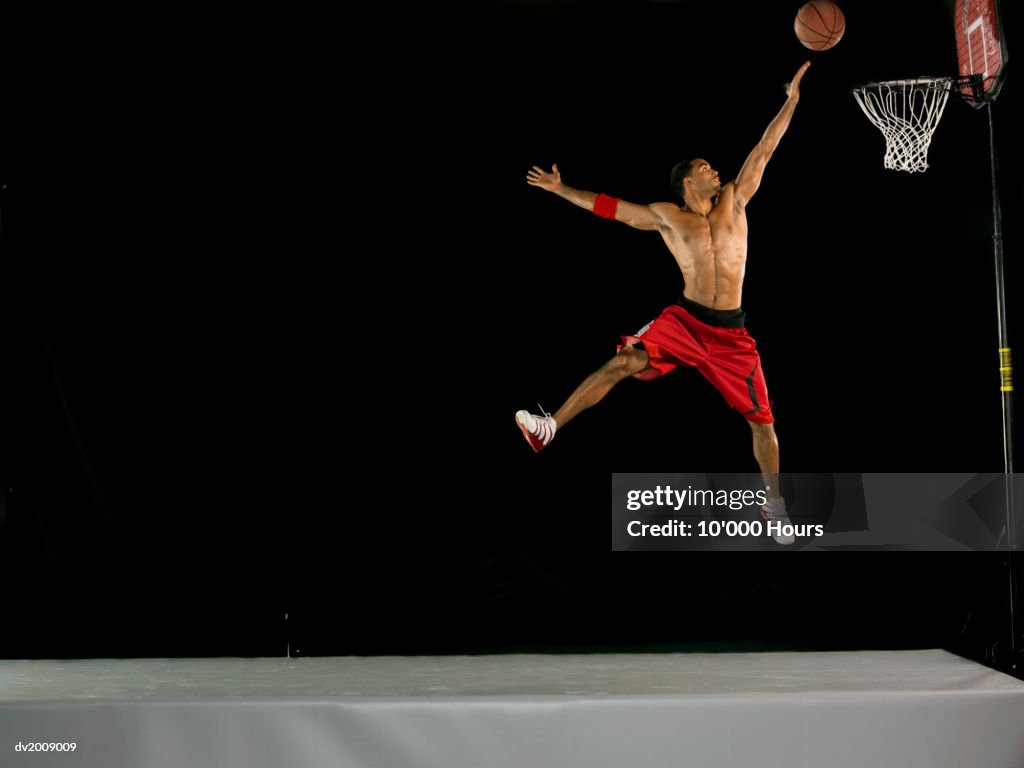 Male Basketball Player in Mid Air and Aiming for the Hoop, Studio Shot