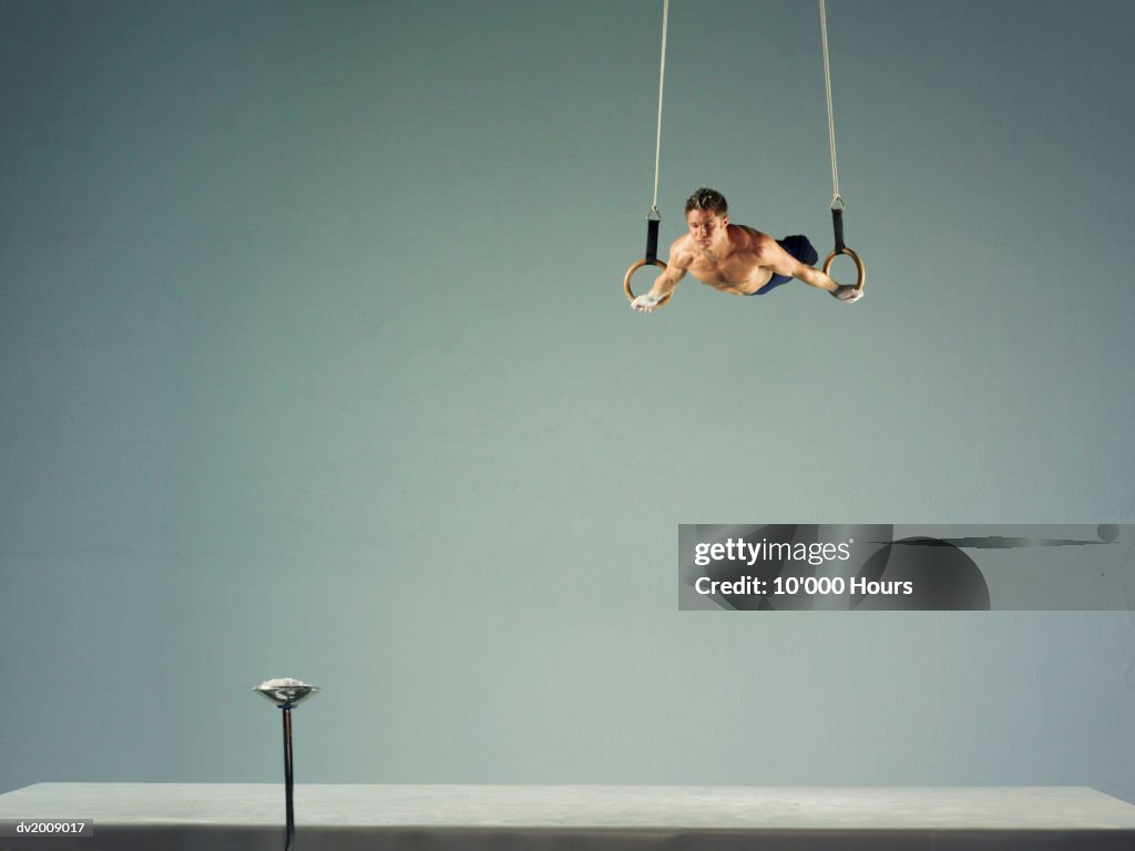 Male Athlete Practising a Rings Exercise