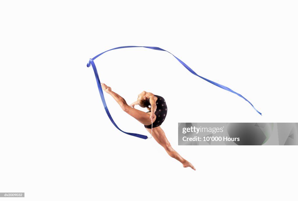 Female Athlete Jumping Gracefully Mid Air With a Ribbon