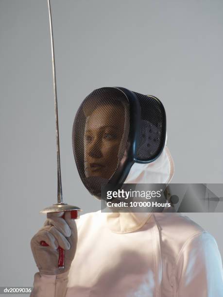 female fencer with a mask on holding her epee straight - fäktningsmask bildbanksfoton och bilder