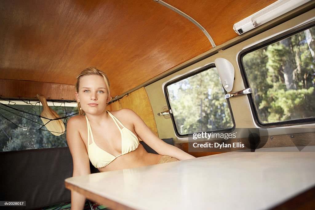 Portrait of a Young Woman Sitting Behind a Table in a Motor Home
