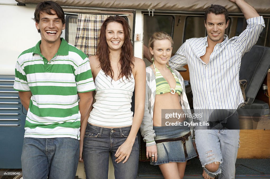 Four Young Men and Women Standing in Front of a Motor Home