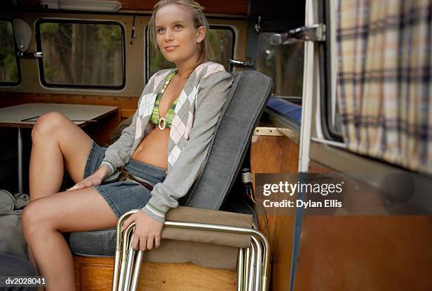 young woman sitting on a bench in a motor home - ellis stock-fotos und bilder