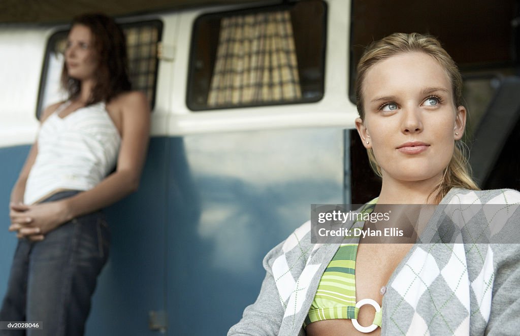 Thoughtful Young Woman Sitting in Front of a Caravan