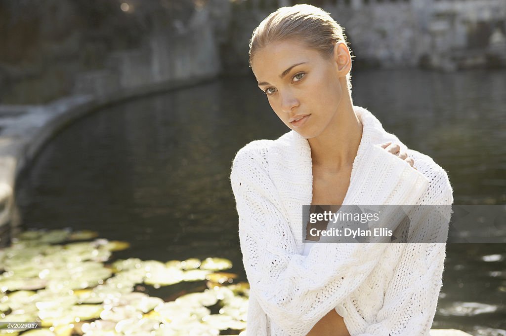 Portrait of a Young Woman Wearing a Woolen Cardigan by a Lake