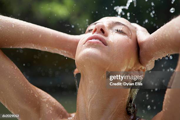 woman washing her hair under an outdoors shower - ellis stock-fotos und bilder