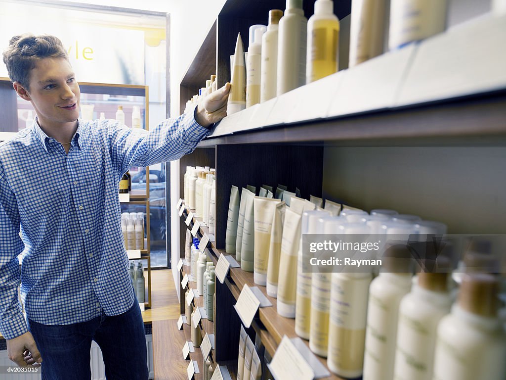 Man Looking at Hair Products in a Hair Salon
