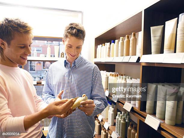 hairdresser showing a man hair products - beauty care occupation stock pictures, royalty-free photos & images