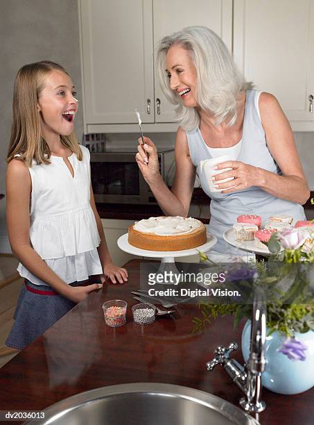 grandmother putting icing on her granddaughter's nose - throwing cake stock pictures, royalty-free photos & images