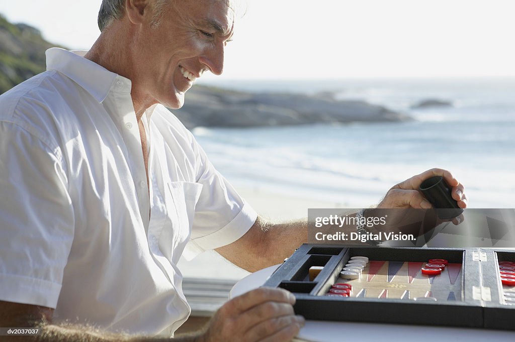 Senior Man Playing Backgammon by the Coast