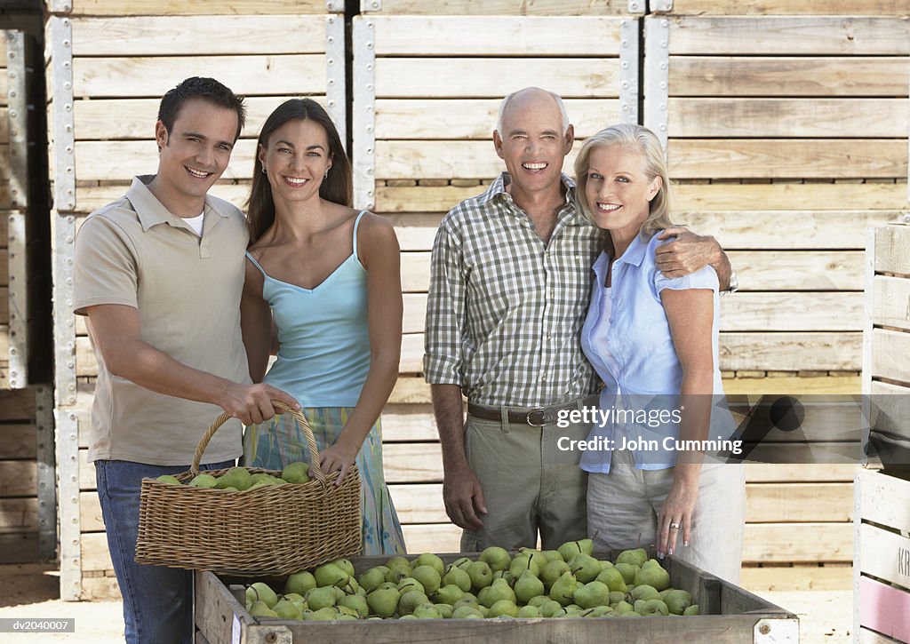Family of Four Standing By a Crate of Pears