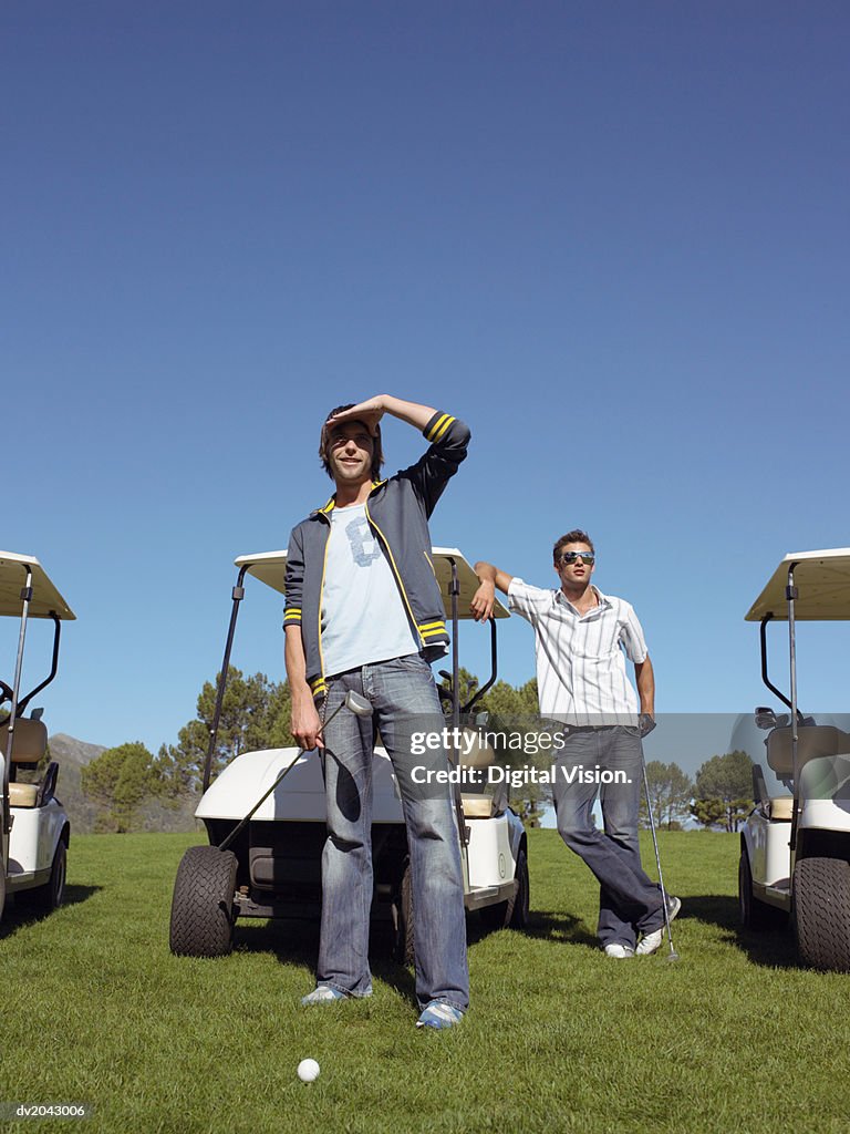 Young Man on a Golf Course Shielding His Eyes as He Looks Ahead