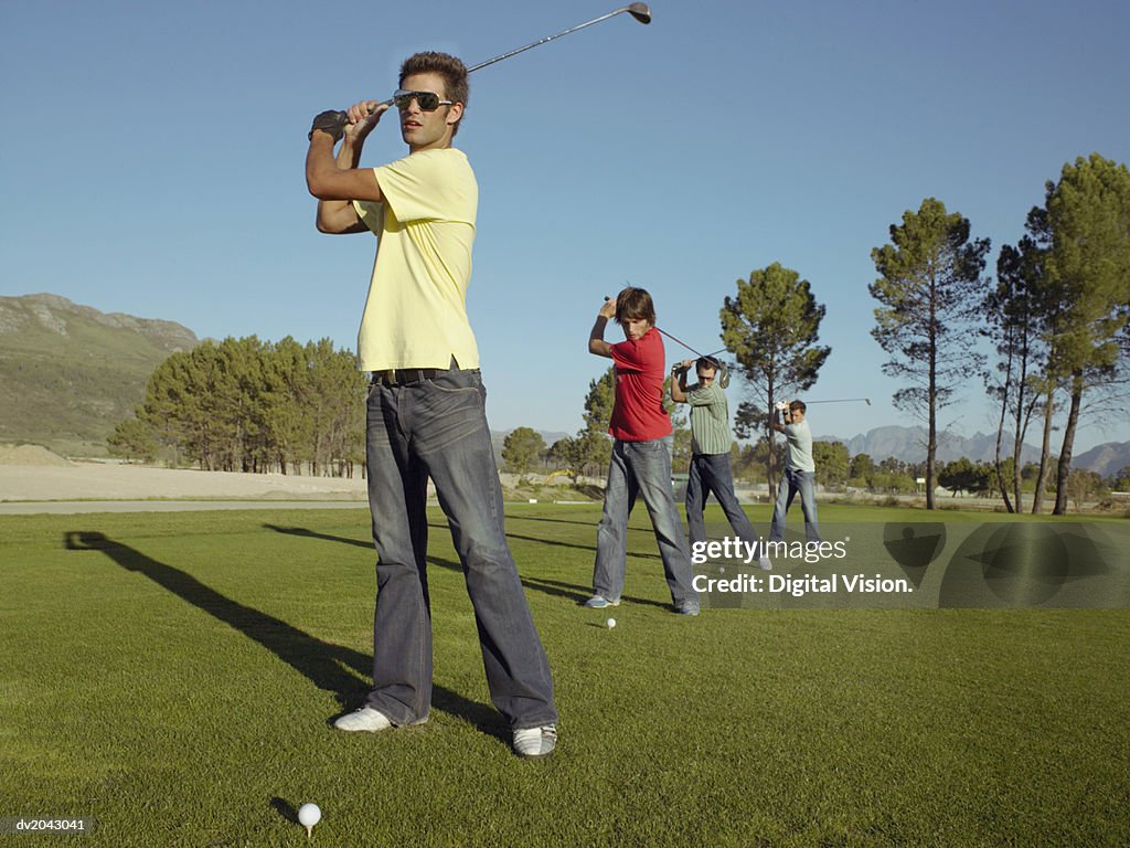 Four Young Men Playing Golf on a Golf Course
