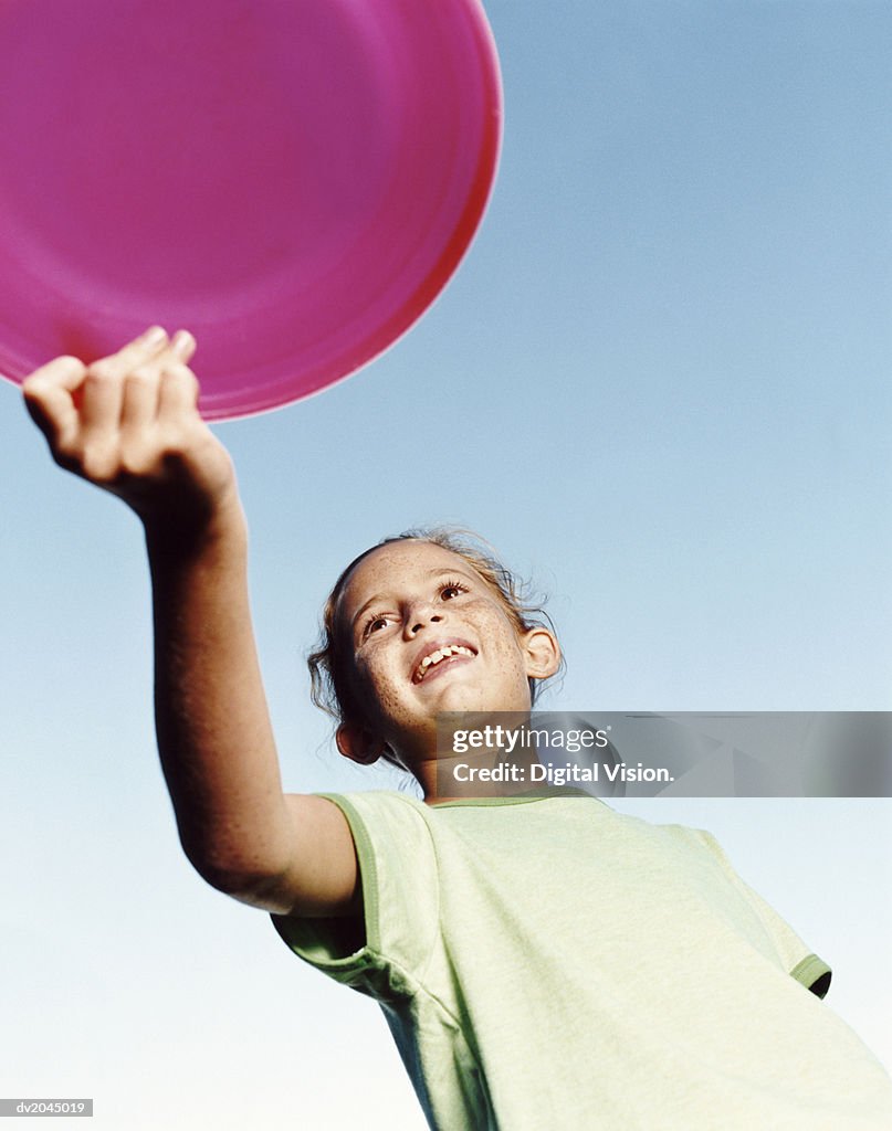 Low Angle of a Young Girl Holding a Pink Frisbee