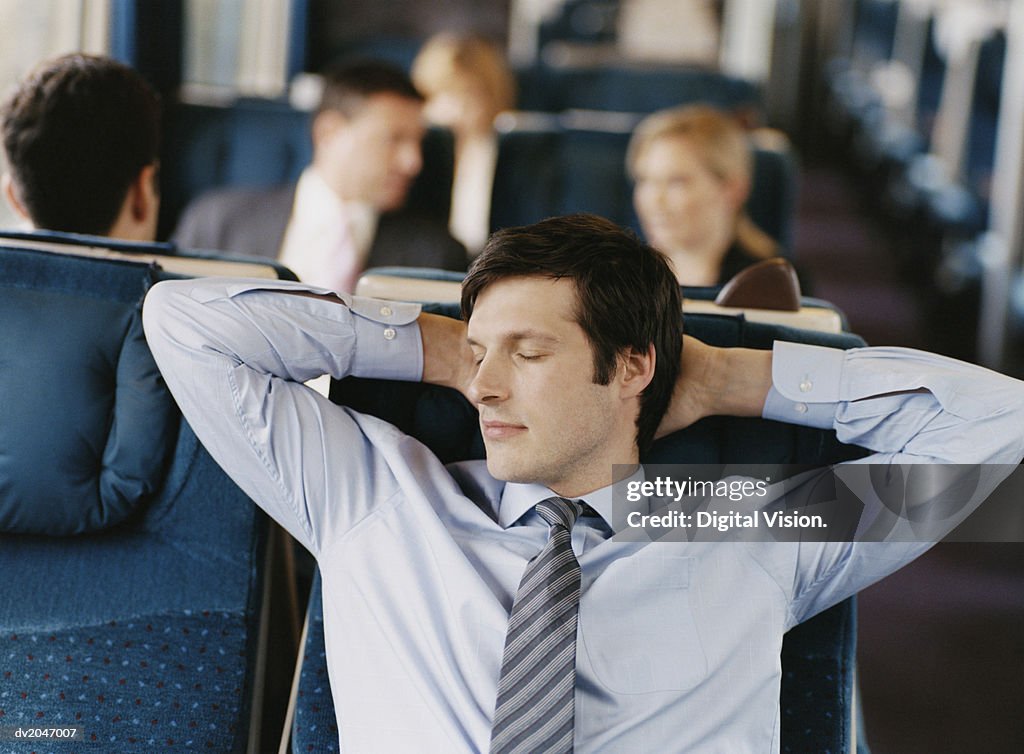 Businessman Asleep in His Seat on a Passenger Train