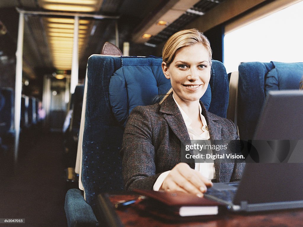 Portrait of a Smiling Businesswoman Sitting on a Passenger Train