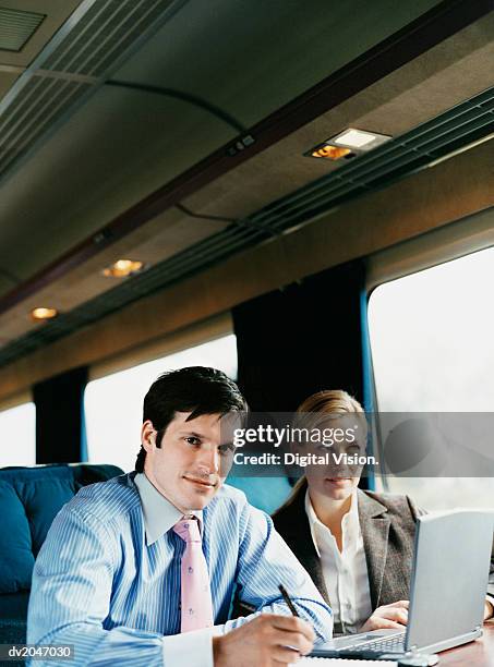 businesswoman and businessman working in a train - digital devices beside each other bildbanksfoton och bilder