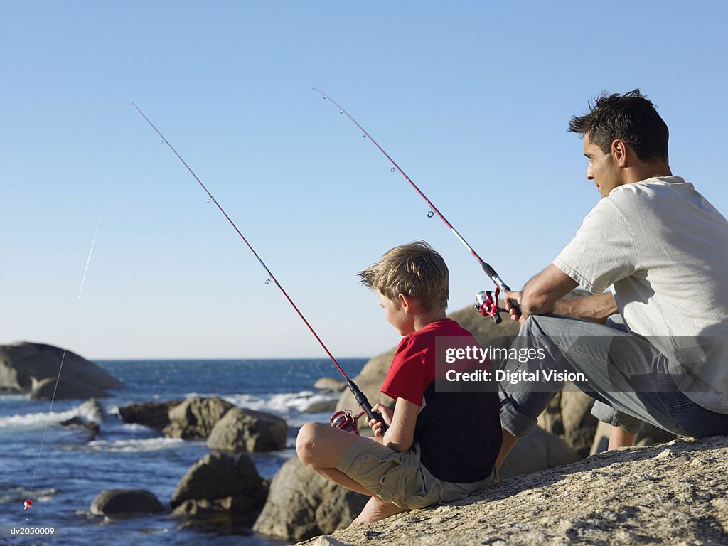 Father and Son Fishing on a Rock