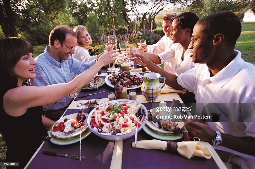 People toasting at an outside dinner party