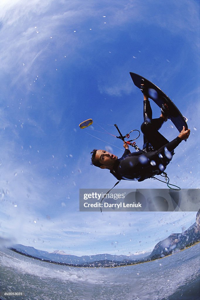 Fish Eye Lens Shot of a Kite Surfer Performing a Stunt in Mid Air