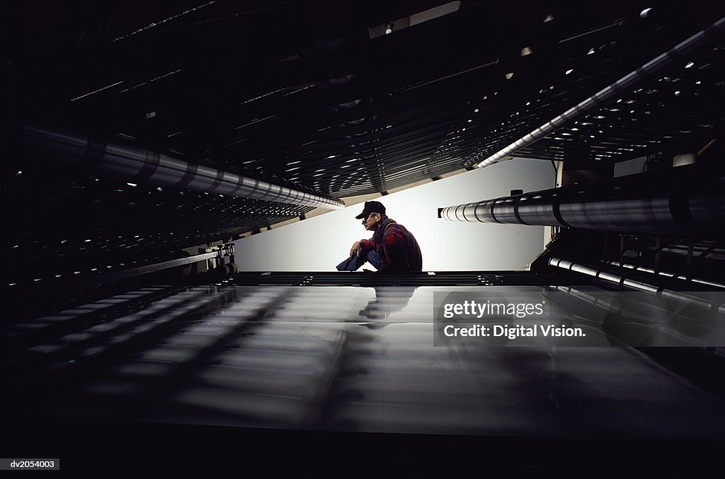 Man Seen Through a Tunnel in an Industrial Plant