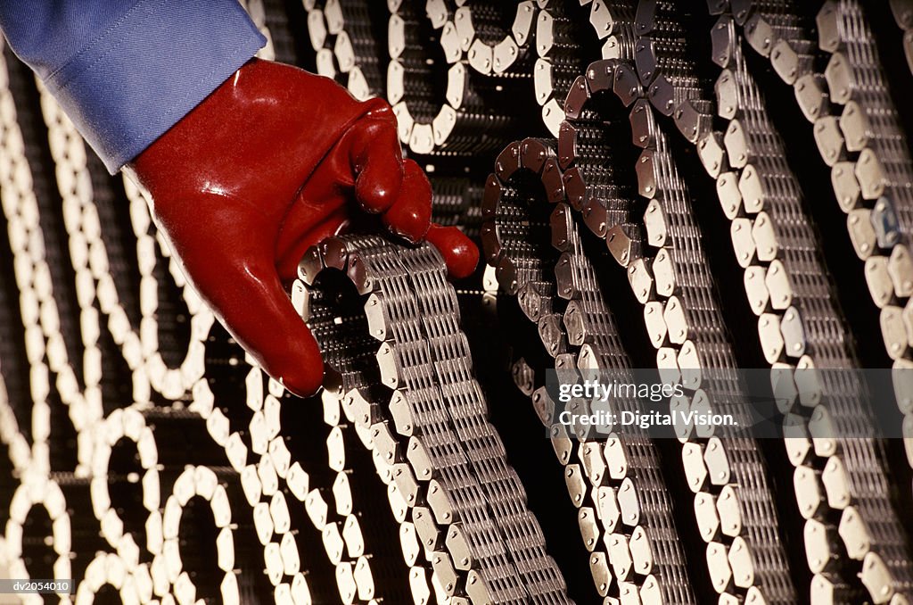 Red Gloved Hand Removing a Coiled Chain