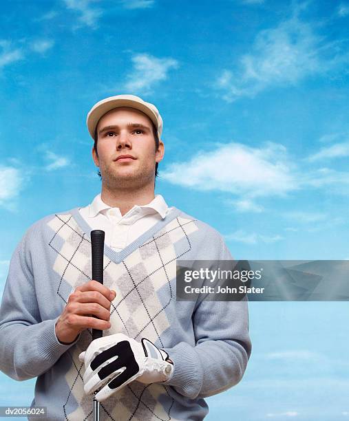 golfer wearing a flat cap and holding a golf club - flat cap stock-fotos und bilder