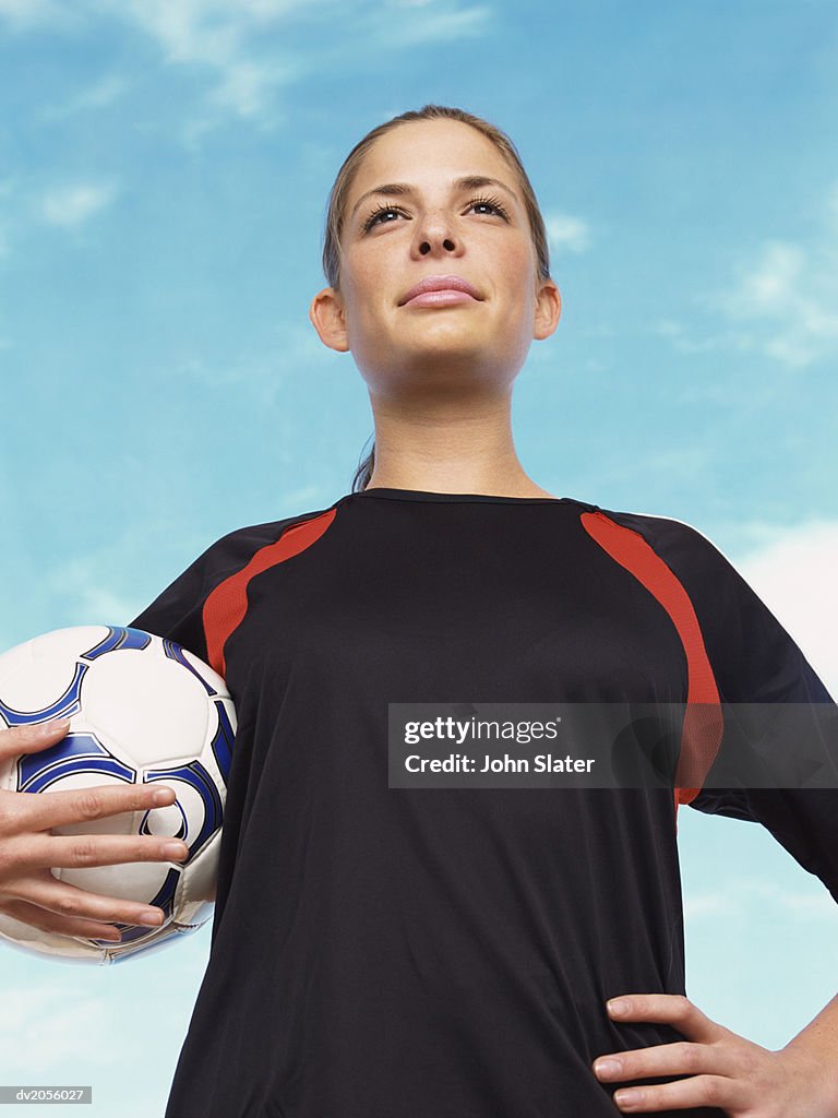 Portrait of a Confident Female Football Player Holding a Football