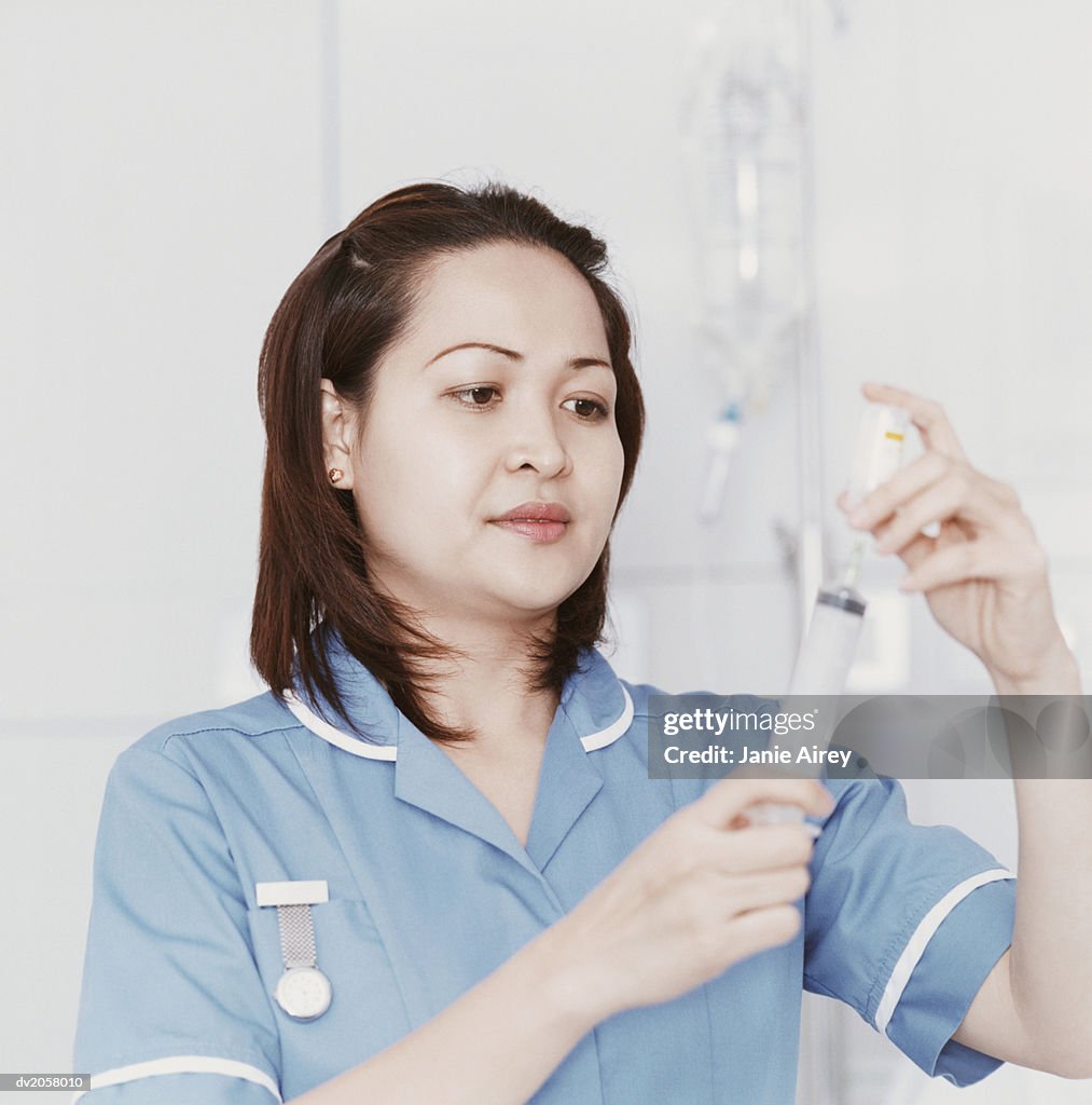 Female Nurse Measures Medicine Into a Syringe