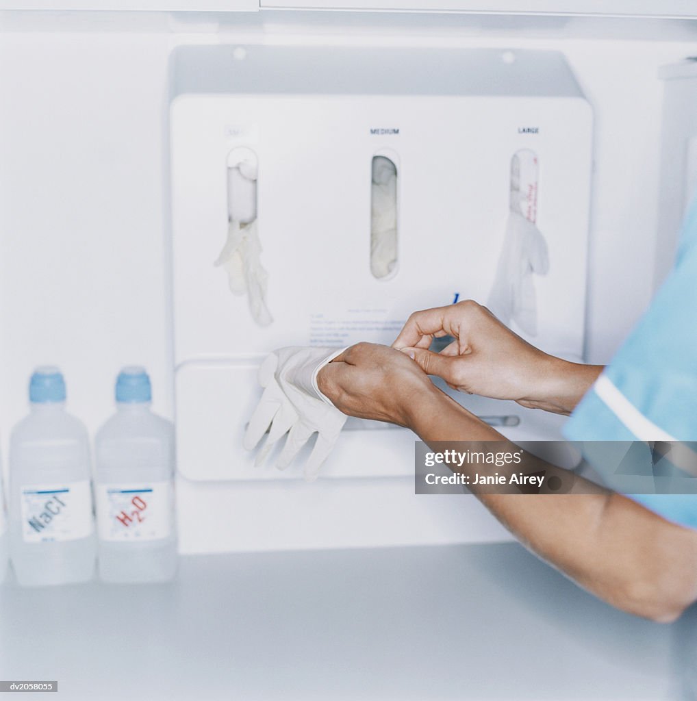 Female Nurse Putting on PVC Gloves