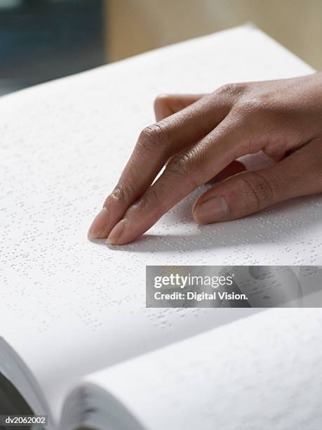 close up of a hand touching a braille book - braille foto e immagini stock