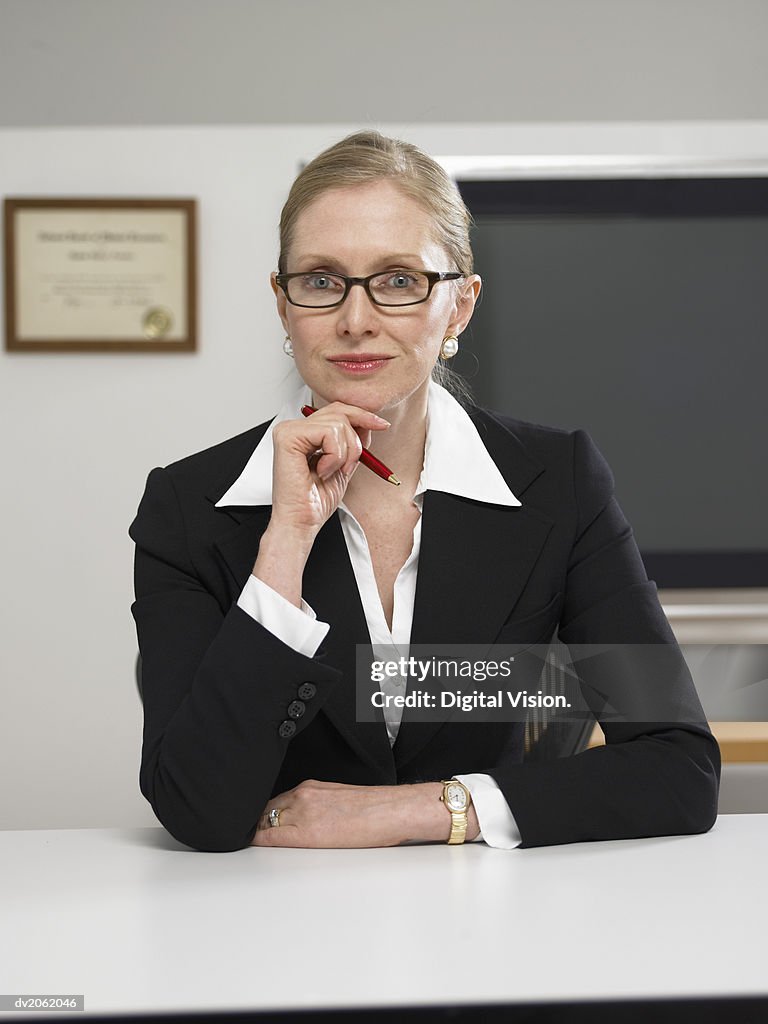 Portrait of a Female GP Sitting at Her Desk in Her Clinic