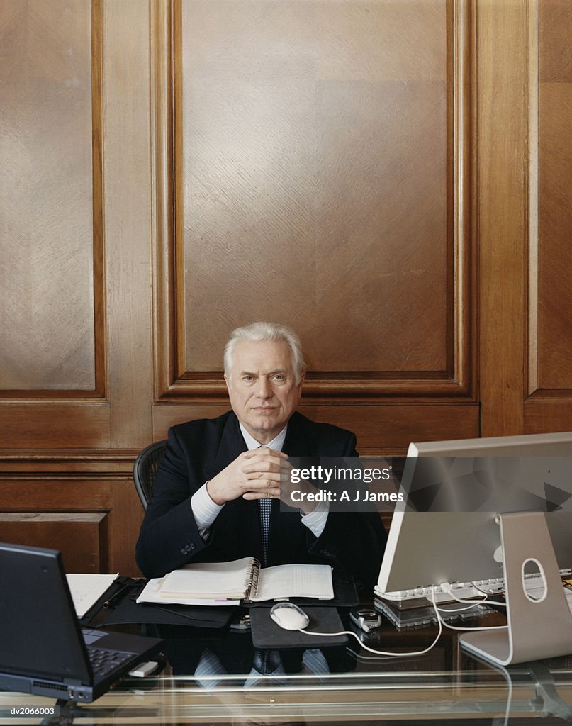 Portrait of a Serious Looking CEO Sitting at His Desk