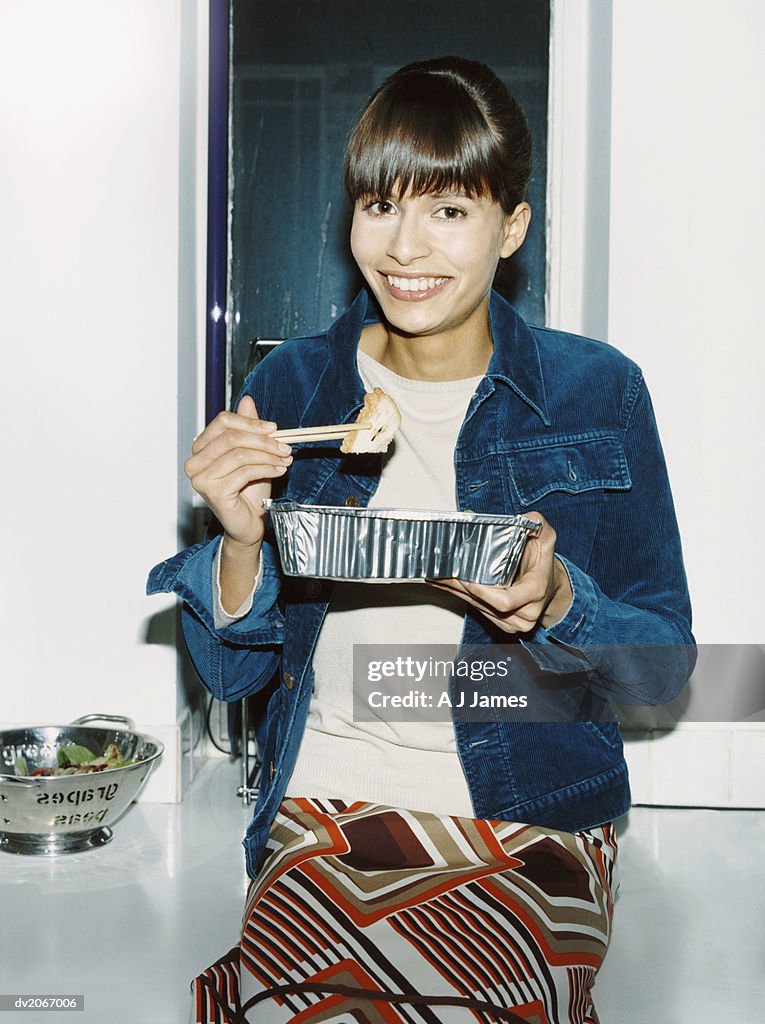 Portrait of a Young Woman Holding a Disposable Fast Food Container and Chopsticks