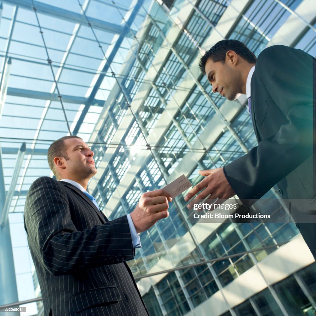 Businessman Hands His Business Card to a Colleague