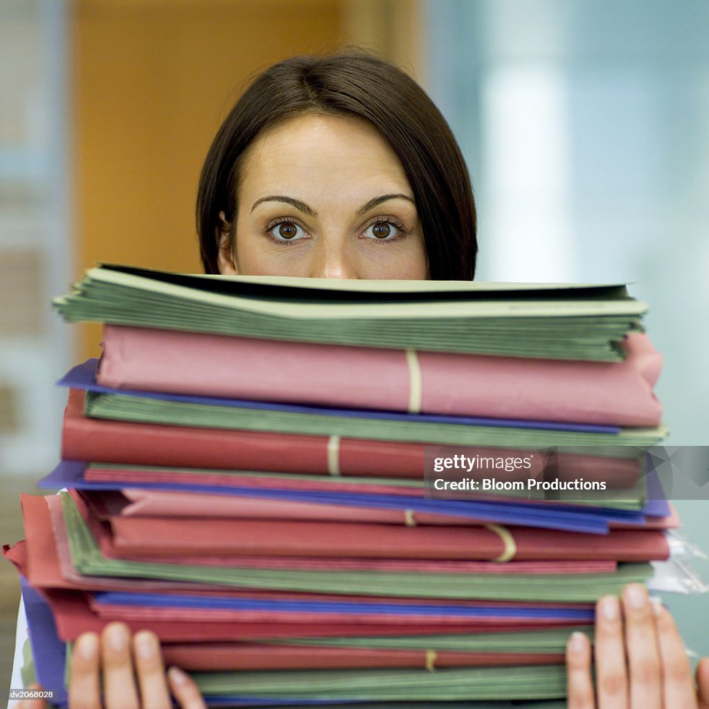 Woman Carrying a Big Pile of Folders, Her Face Obscured