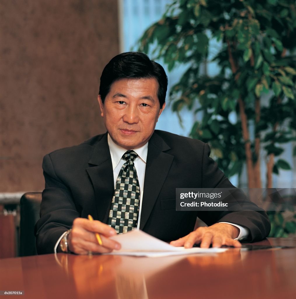 Confident Asian man at desk