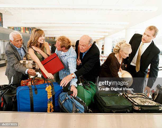 people searching for their luggage at an airport baggage collection - searching for something ストックフォトと画像