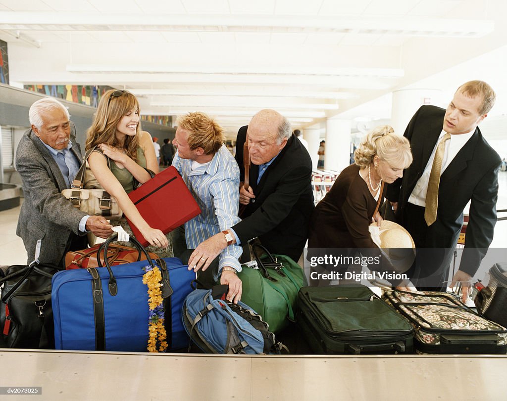 People Searching For Their Luggage at an Airport Baggage Collection