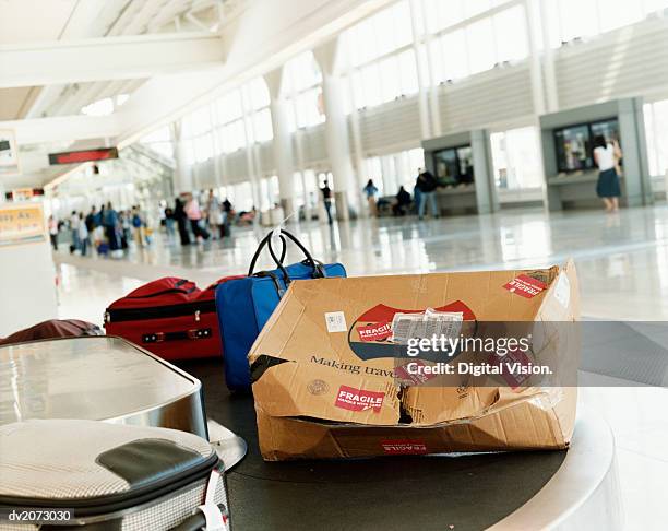 damaged package on a airport baggage conveyor belt - fragile sign stock pictures, royalty-free photos & images
