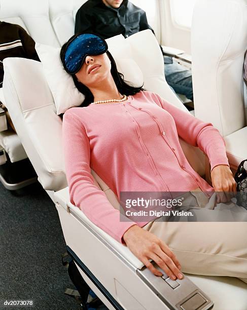 passenger sleeping in an aircraft cabin interior - recostarse fotografías e imágenes de stock