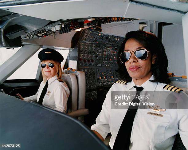 portrait of female pilots sitting at the cockpit - aviatrice stock-fotos und bilder