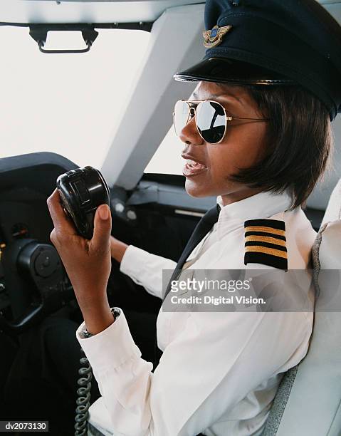 female pilot talking into a radio - uniformmütze stock-fotos und bilder