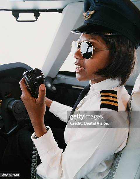 female pilot talking into a radio - uniform cap imagens e fotografias de stock