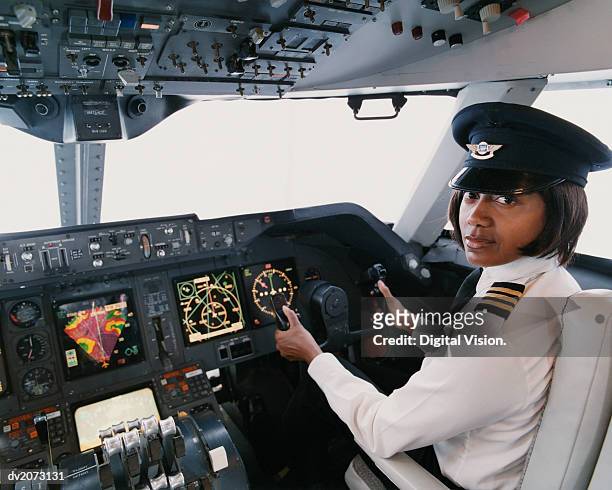 portrait of a female pilot sitting in the cockpit - berretto da uniforme foto e immagini stock