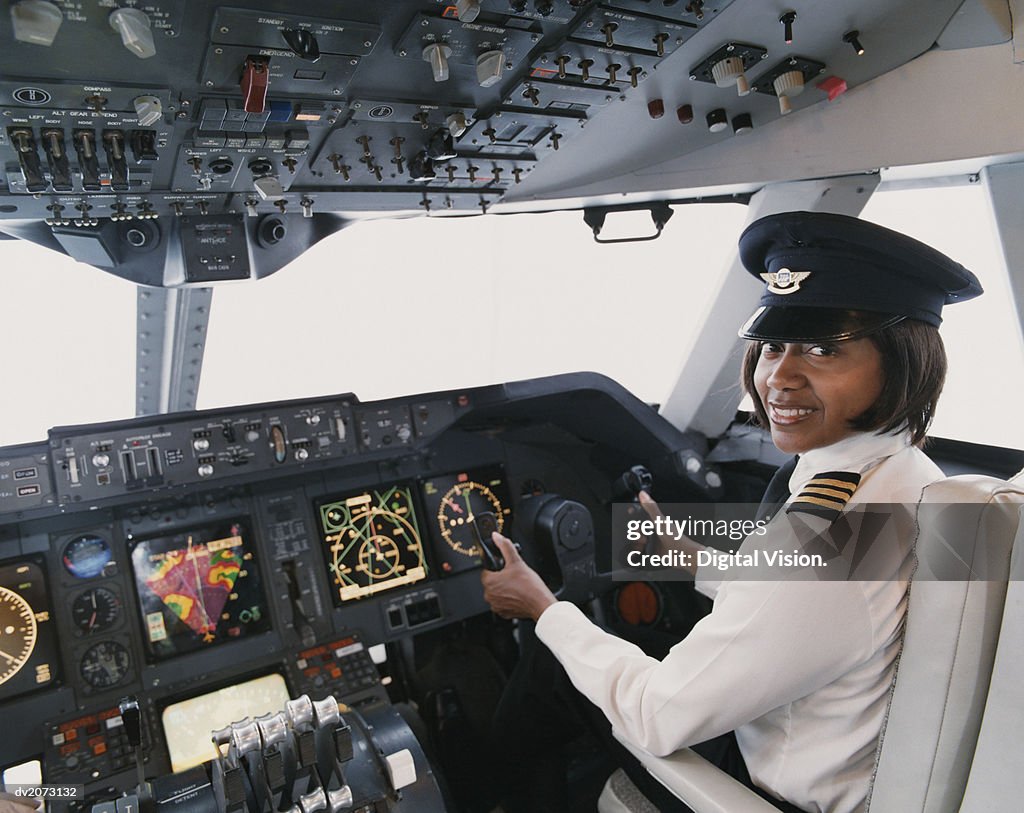 Portrait of a Female Pilot Sitting in the Cockpit