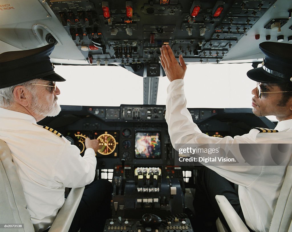 Portrait of Pilots Sitting in the Cockpit, Adjusting the Controls