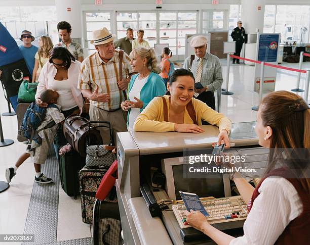 queue of tourists at an airport check-in desk - check up ストックフォトと画像