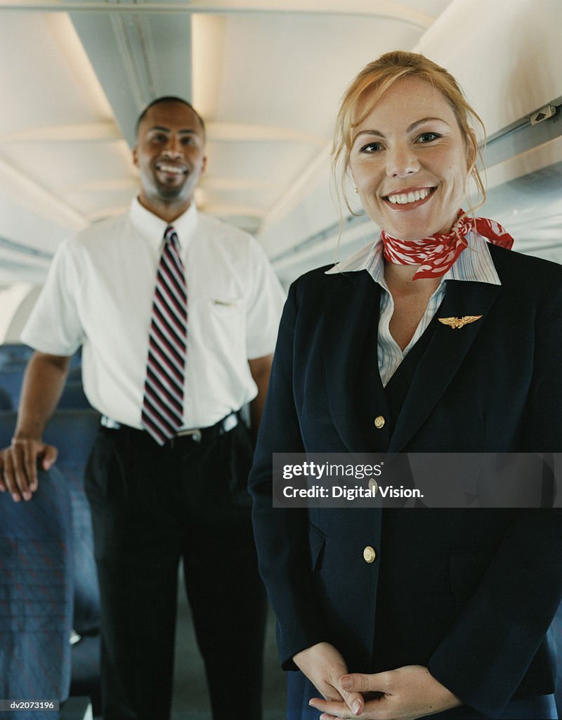 Two Flight Attendants Standing in the Cabin of a Plane